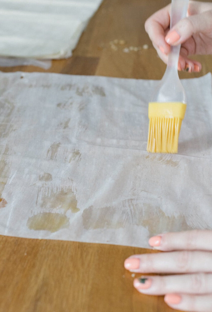 Phyllo dough being brushed with butter